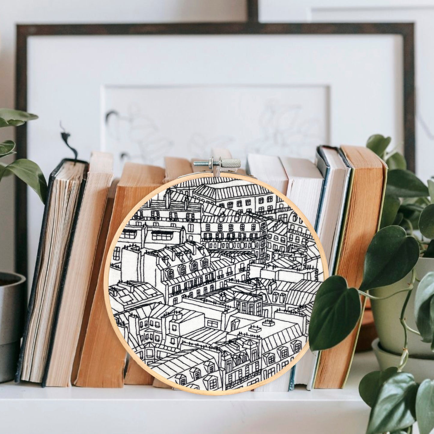 Rooftops of Paris France Embroidery Hoop Art Displayed on a Shelf with books